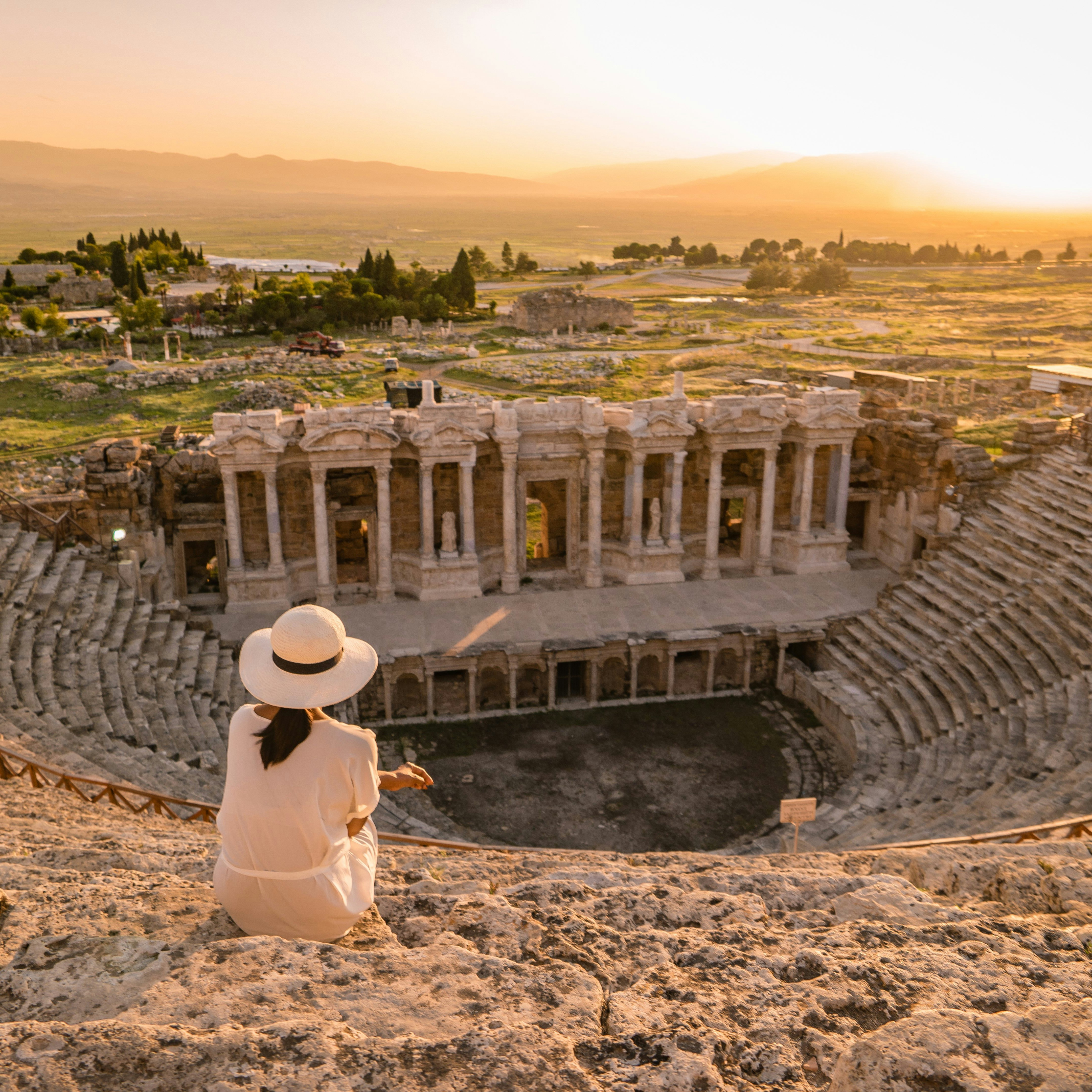 Hierapolis ancient city Pamukkale Turkey, young woman with hat watching sunset by the ruins Unesco ; Shutterstock ID 1167278944; your: Bridget Brown; gl: 65050; netsuite: Online Editorial; full: POI Image Update